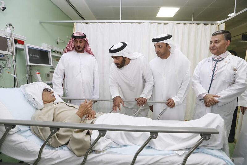 FNC members Ahmed Al Ameri, Salem Al Ameri,  and Salim bin Huwaidan, speak to a patient at Sheikh Khalifa General Hospital in Umm al Quwain. Sarah Dea / The National