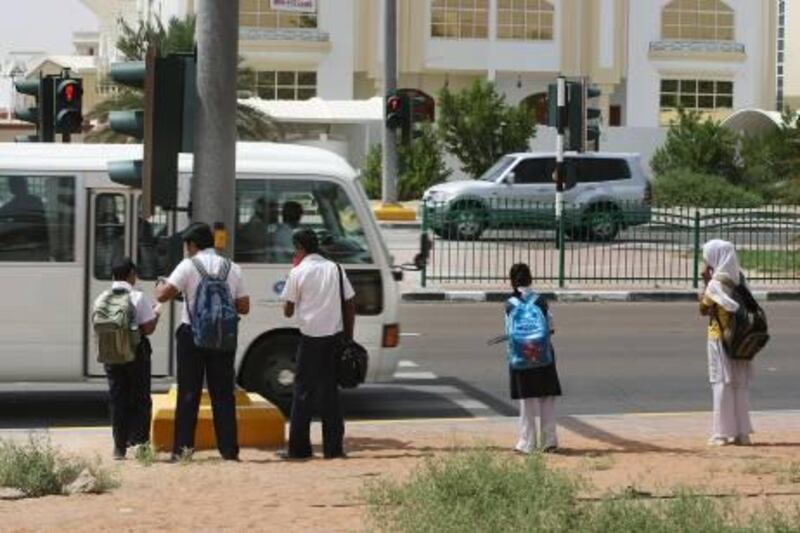 United Arab Emirates --- May 20, 2010 --- School children wait to cross a street in Al Ain at a pedestrian cross walk. ( Delores Johnson / The National )
