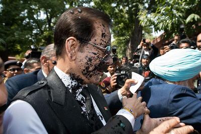 Black ink is thrown at India's Sahara group chairman Subrata Roy's face as he arrives at the Supreme Court in New Delhi. Prakash Singh / AFP Photo