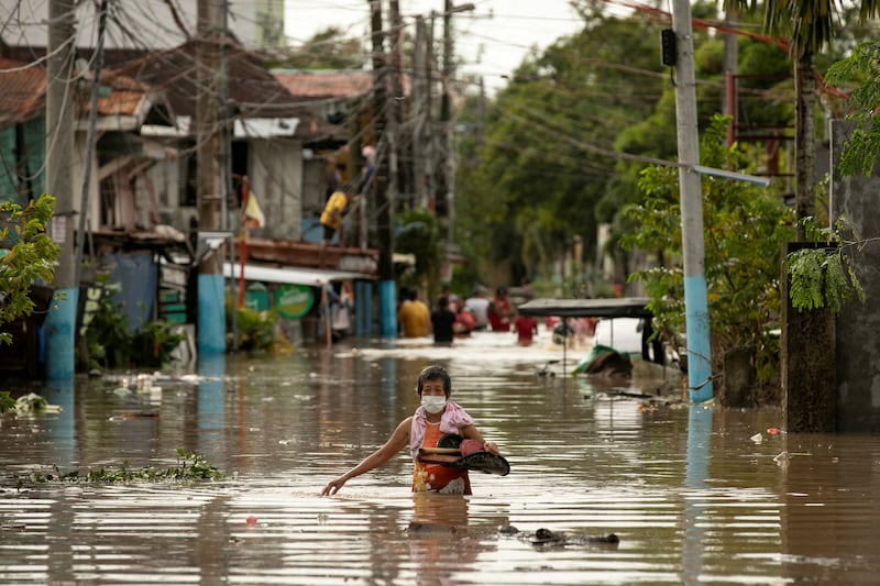 Residents wade through waist-deep flood waters. Reuters