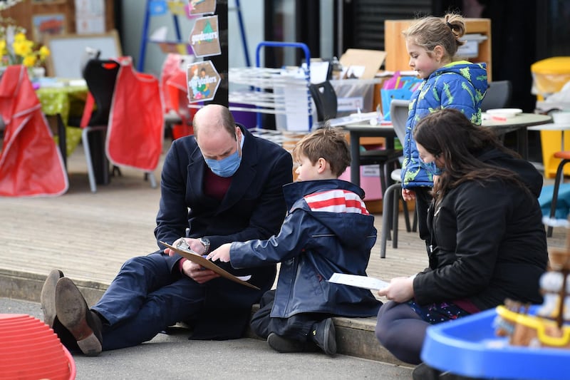 Prince William speaks to a child in the playground during a visit to School21. AFP