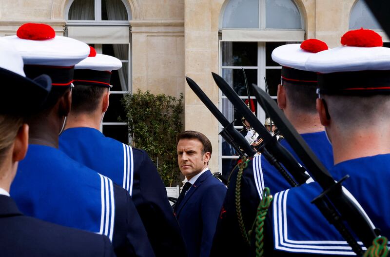 Mr Macron reviews military troops. AP