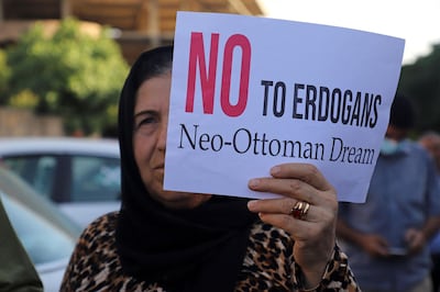 A woman lifts a placard as Iraqi Kurds demonstrate  in the northeastern city of Sulaimaniyah on June 5, 2021, protesting a Turkish offensive in northern Iraq. Three civilians were killed in a Turkish drone attack on a refugee camp in northern Iraq in an area which Turkish President Recep Tayyip Erdogan recently threatened to "clean up". / AFP / Shwan MOHAMMED
