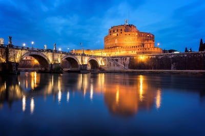 View of the Ponte and the Castel Sant'Angelo in Rome (Italy). The picture was taken during the blue hour near the Tiber river during the Spring. This location is well known in Rome and closed to the Vatican.