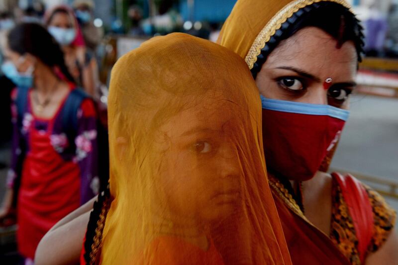 A woman carrying a child waits to board a special train to Rajasthan after the government eased a nationwide lockdown imposed as a preventive measure against the COVID-19 coronavirus, at MGR Central railway station in Chennai, India. AFP