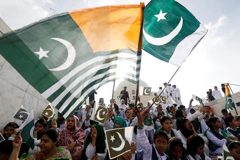 Pakistantis wave Pakistan's national flag and Kashmir's flag  in Karachi on Pakistan's Independence Day. Reuters