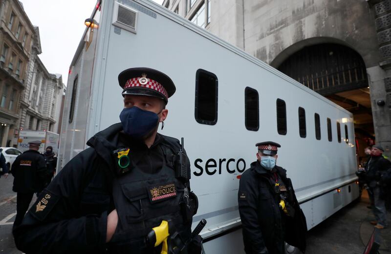 Police guard a prisoner transport van as it arrives at the Old Bailey. AP Photo