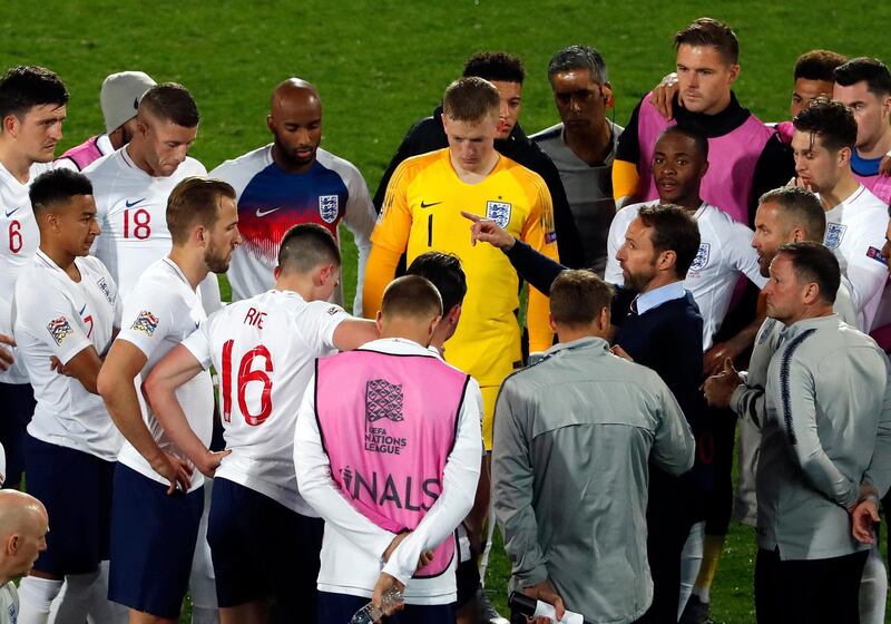 Southgate, center right, talks to the players drumming the break before extra time. AP Photo