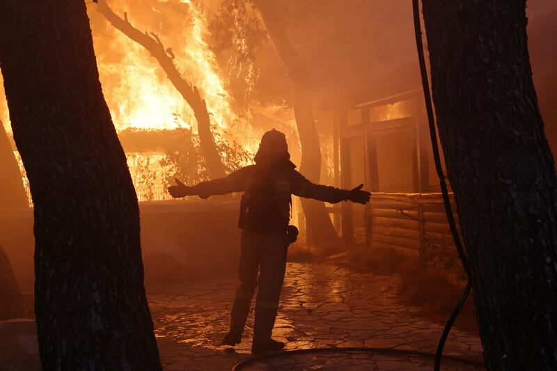 A firefighter approaches a wildfire in Varympompi, north of Athens, Greece.