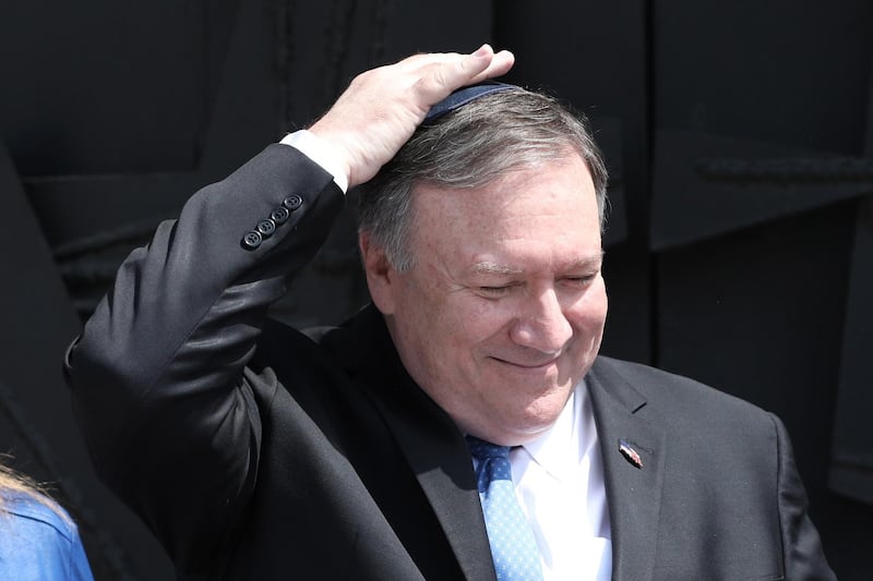epa07452566 US Secretary of State Mike Pompeo touches his skullcap after signing the guestbook at the Yad Vashem Holocaust memorial museum in Jerusalem, Israel, 21 March 2019. Pompeo is on a five-day trip to the Middle East where he is visiting Kuwait, Israel and Lebanon.  EPA/ABIR SULTAN