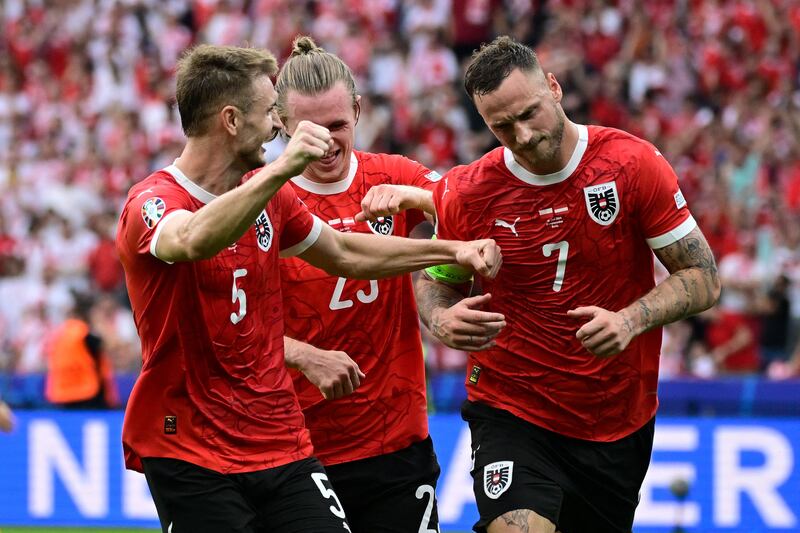 Austria's Marko Arnautovic celebrates with teammates after scoring his team's third goal against Poland in their Euro 2024 Group D match at the Olympiastadion in Berlin. AFP