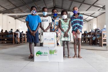 Children pose for the camera after receiving their food packets. Wam