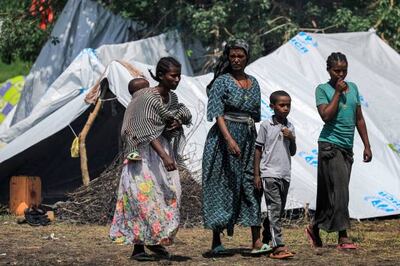 Women and children walk about at a camp for Ethiopian refugees of the Qemant ethnic group in the village of Basinga in Basunda district of Sudan's eastern Gedaref region on August 10, 2021. AFP