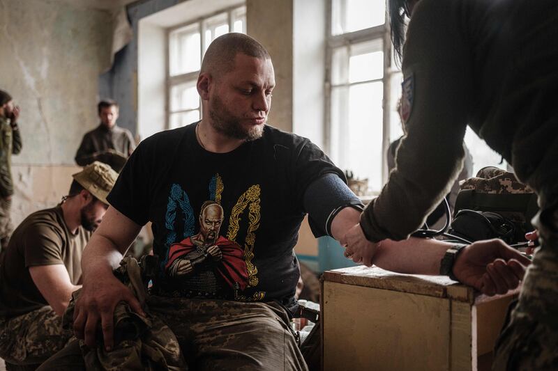 A Ukrainian soldier receives medical treatment as he and others rest after fighting on the front line for two months near Kramatorsk. AFP