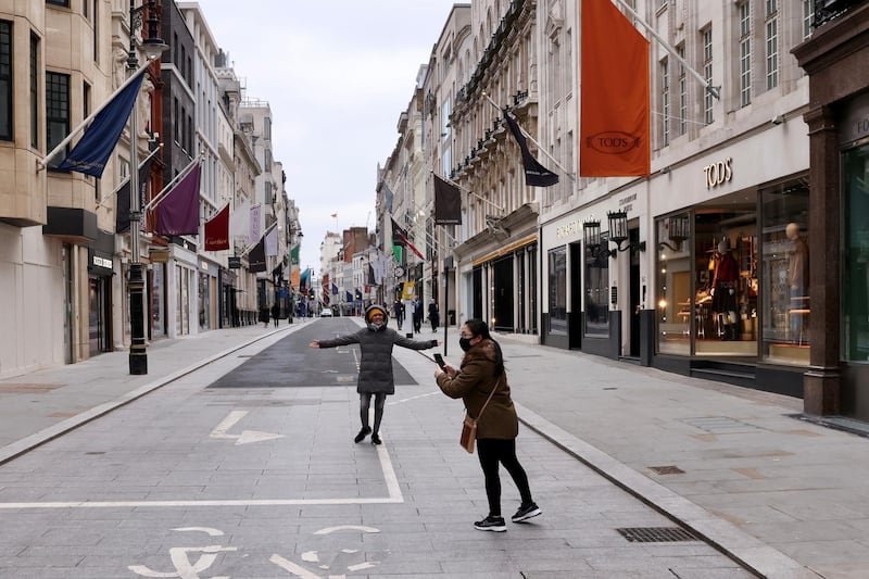 People take pictures in a deserted Old Bond Street in London. Reuters