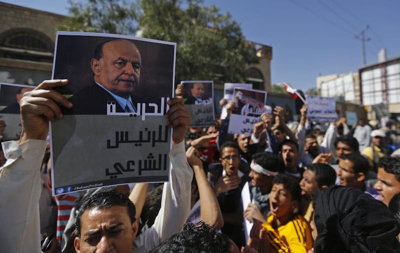 A protester holds up a poster of Yemen's former president Abdrabu Mansur Hadi during an anti-Houthi demonstration in Sanaa on February 21, 2015. Mr Hadi fled his official residence after weeks of house arrest by the Houthi militia on Saturday. Khaled Abdullah / Reuters