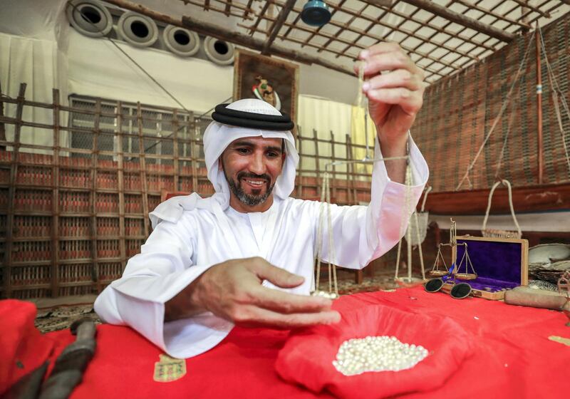 Abu Dhabi, U.A.E., July 18, 2018.  First day of the 2018 Liwa Date Festival.   Mohamed Ateeq Almehairbi, Emirates Heritage Club  weighs some pears at the festival.
Victor Besa / The National
Section:  NA
Reporter:  Haneen Dajani