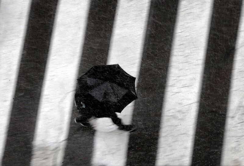 A man walks under his umbrella during a rainy day in Valencia, eastern Spain. EPA