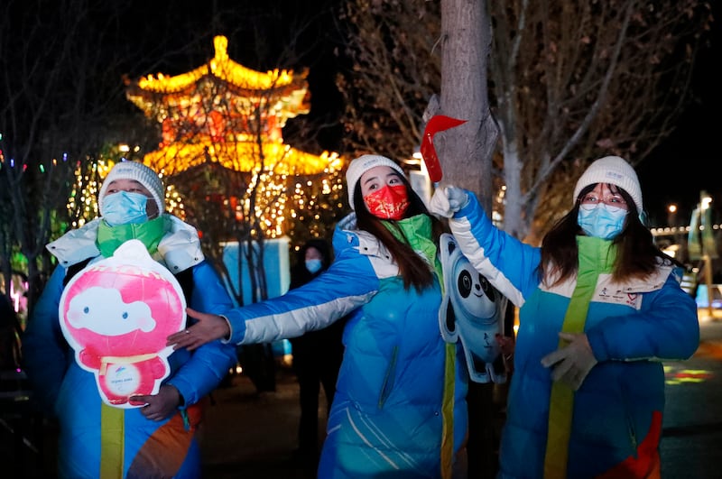 Volunteers hold placards of Bing Dwen Dwen and Shuey Rhon Rhon, mascots of the Beijing 2022 Winter Olympics and Paralympics, during a community event at an Olympics Live Site before the Beijing 2022 Winter Olympics opening ceremony, in Beijing, China. Reuters