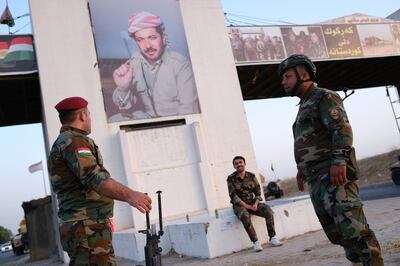 Kurdish Peshmerga fighters take up position under a photo of Masoud Barzani the president of the Kurdistan Democratic Party, on the outskirts of Kirkuk city. EPA