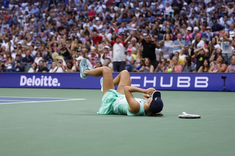 Iga Swiatek slumps to the court in celebration after winning the 2022 US Open. AFP