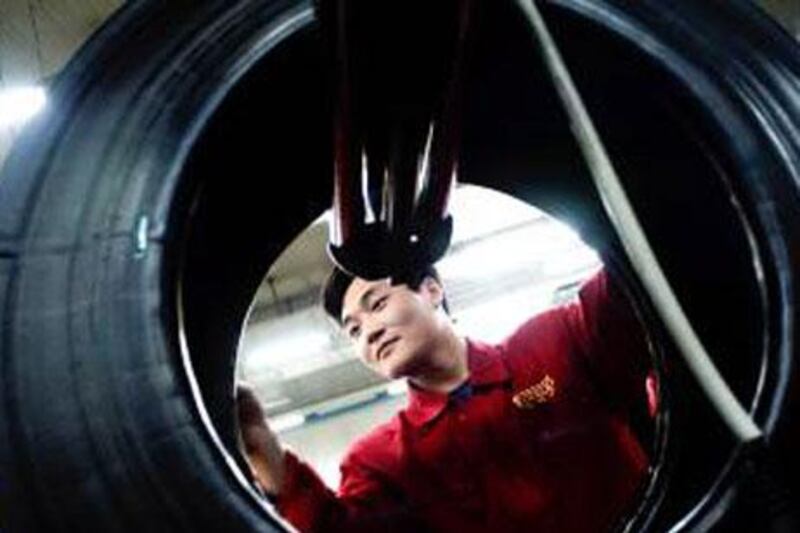 A worker inspects a Pirelli tyre. The Italian manufacturer says it will supply an extra set of tyres to Formula One teams for this weekend's Spanish Grand Prix.