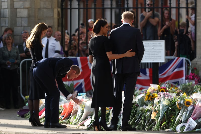 Britain's William, Prince of Wales, second left, his wife Catherine, Princess of Wales, left, along with Prince Harry and his wife Meghan, the Duchess of Sussex, look at floral tributes as they walk outside Windsor Castle. Reuters