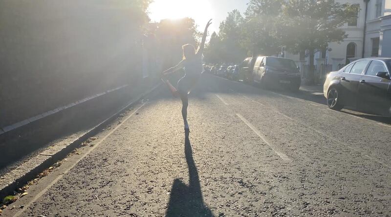 The silhouette of a dancer can be seen against the light in a London street. Reuters