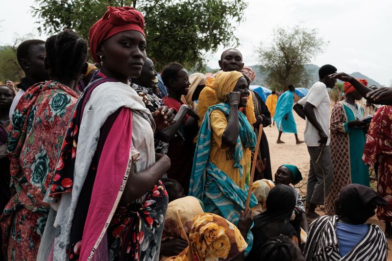 People wait to receive food cards a camp for internally displaced people in North Kordofan. Sudan's military and the paramilitary Rapid Support Forces have been fighting since April last year.
