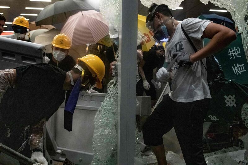Protesters smash glass doors and windows of the government headquarters. AFP