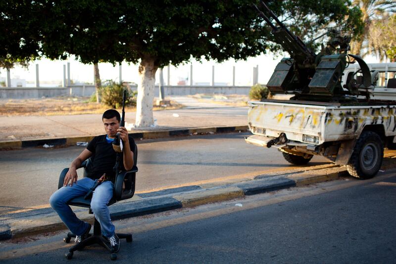 TRIPOLI, LIBYA - AUGUST 25: A Libyan Rebel fighter sits at a check point on August 25, 2011 in Tripoli, Libya. Heavy fighting continues in the Libyan capital between Gaddafi's forces and the surging rebel presence. The Rebels, who have issued a $1.7m reward for Gaddafi's capture "dead or alive", are attempting to reach Colonel Gaddafi's hometown of Sirte but have met loyalist resistance. (Photo by Daniel Berehulak/Getty Images) *** Local Caption ***  122142416.jpg