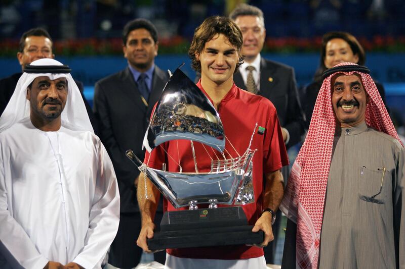 Swiss world number one Roger Federer (C) holds up his trophy as he stands beside Sheikh Ahmed Bin Said al-Maktoum (L) Emirates airline chairman and Sheikh Hasher al-Maktoum, GCC Tennis Federation president, after winning the ATP Dubai Men's Duty Free final against Ivan Ljubicic of Croatia, in Dubai 27 February 2005. Federer won 6-1, 6-7(8/6), 6-3.AFP PHOTO/RABIH MOGHRABI (Photo by RABIH MOGHRABI / AFP)