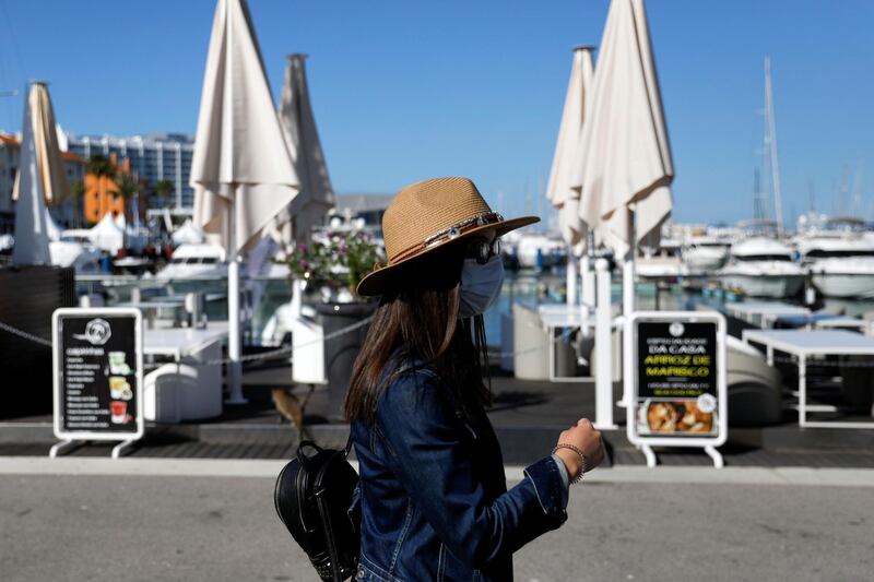 A person wearing a protective mask walks in Vilamoura marina amid the coronavirus disease (COVID-19) pandemic, in Quarteira, Portugal, June 4, 2021. REUTERS/Pedro Nunes