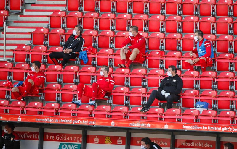Union Berlin substitutes wear face masks and maintain social distance in the stands. AFP