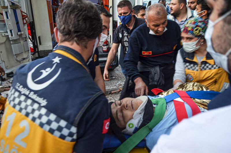 Rescuers and local volunteers carry a wounded victim on a stretcher from a collapsed building after a powerful earthquake struck Turkey's western coast and parts of Greece, in Izmir.  AFP