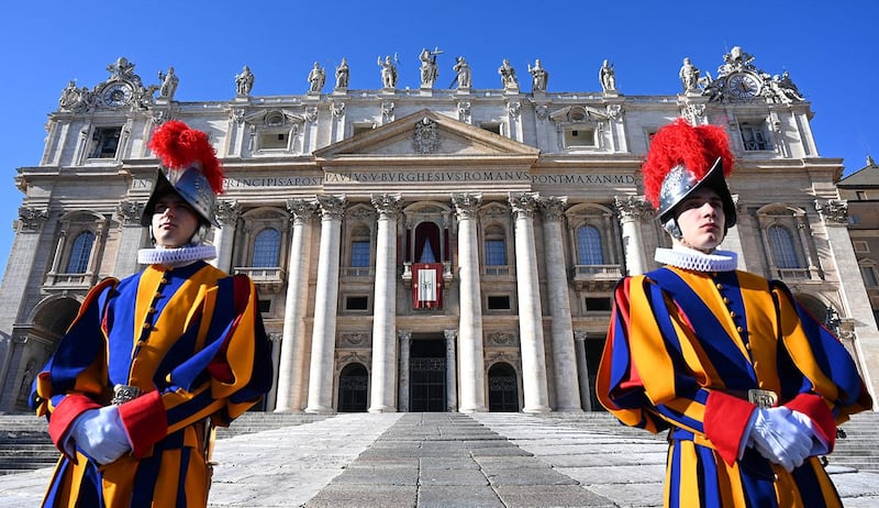 Swiss guards stand in front of St Peter's Basilica before the appearance of Pope Francis at the balcony for the traditional "Urbi et Orbi" Christmas message to the city and the world, at St Peter's square in Vatican, on December 25, 2019. (Photo by Alberto PIZZOLI / AFP)
