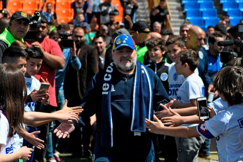 Diego Maradona, manager of Argentine Superliga team Gimnasia, greets fans as he arrives for the match against Godoy Cruz in Mendoza, on Saturday, October 5.  AFP