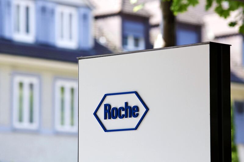 A logo sits on a sign outside the headquarters of Roche AG in Basel, Switzerland, on Tuesday, July, 16, 2013. Roche is seeking billions of dollars in financing for a potential purchase of the $21 billion orphan-drug maker, Alexion Pharmaceuticals Inc., people with knowledge of the situation told Bloomberg News last week. Photographer: Gianluca Colla/Bloomberg