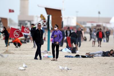 Dubai, United Arab Emirates - January 19, 2019: Standalone. People visit the beach on a dusty windy day in Dubai. Saturday, January 19th, 2019 at the Beach, Dubai. Chris Whiteoak/The National
