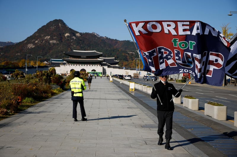 A member of a conservative group waves a flag bearing a message of support for U.S. President Donald Trump in the 2020 U.S. presidential election in front of the U.S. embassy in Seoul, South Korea, November 4, 2020.    REUTERS/Kim Hong-Ji