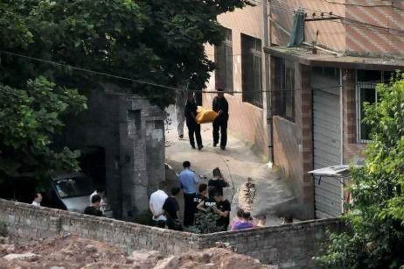 Police carry away the body of Zhou Kehua, the fugitive serial killer and armed robber, from the spot he was shot dead, in Chongqing municipality.