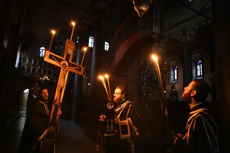 In this Thursday, April 16, 2020 photo, priests participate in the Procession of the Crucifix during Orthodox Easter Week services performed without worshippers to help contain the spread of the coronavirus at the Patriarchal Church of St. George in Istanbul. For Orthodox Christians, this is normally a time of reflection and joy, of centuries-old ceremonies steeped in symbolism and tradition, but this year, the public celebration of Easter has essentially been canceled. (Nikolaos Manginas, Ecumenical Patriarchate Press Service via AP)