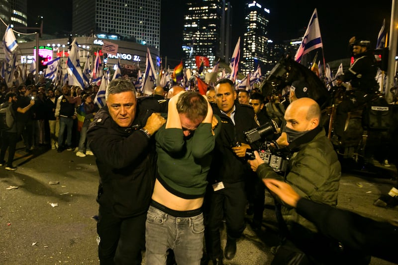 Israeli police officials detain a protester during clashes after a demonstration against the government's judicial overhaul in Tel Aviv. Getty 