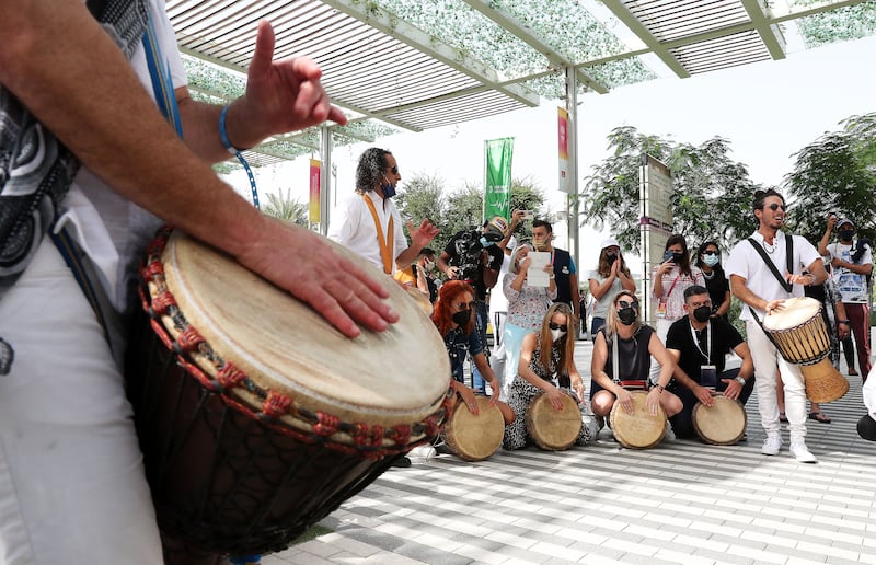 Artists play drums with visitors at the Israeli pavilion.