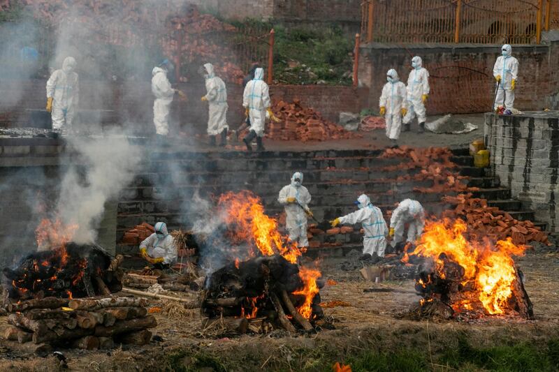 Nepalese men in personal protective suits cremate the bodies of Covid-19 victims near Pashupatinath temple in Kathmandu, Nepal. AP Photo