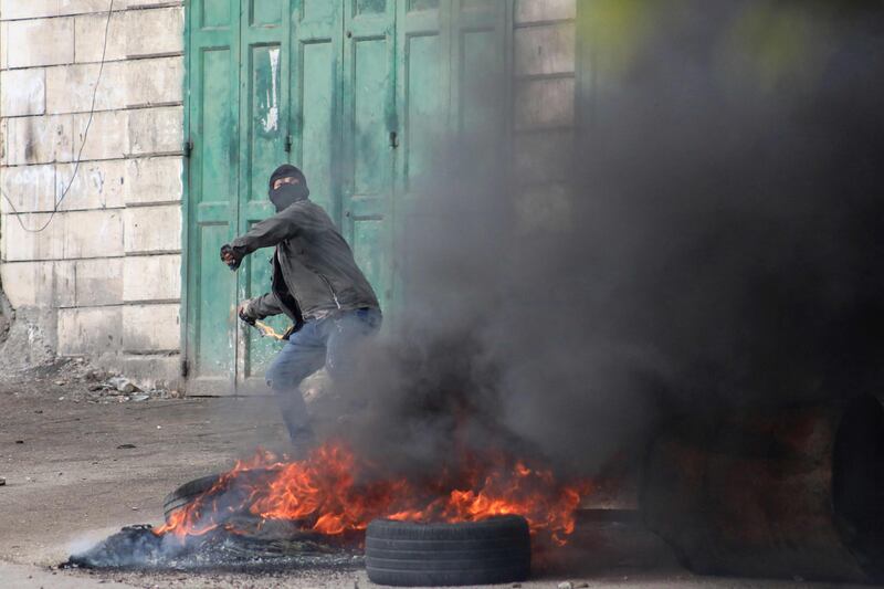 A Palestinian protester throws rocks in Beit Ummar. AFP
