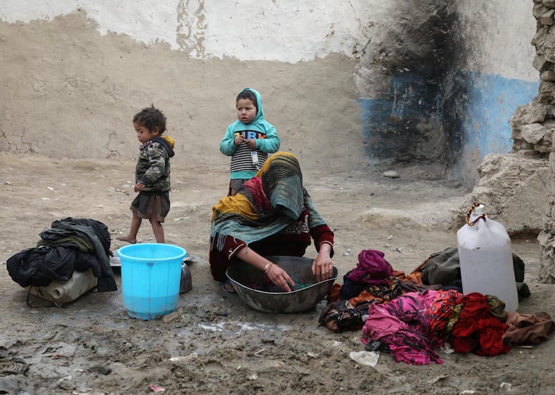 An internally displaced Afghan woman washes clothes outside her shelter on the outskirts of Kabul, Afghanistan February 3, 2021. REUTERS/Omar Sobhani