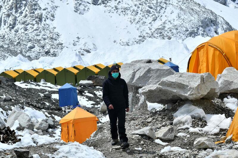 In this picture taken on May 1, 2021  an expedition base camp staff wearing a face mask walks around Everest base camp, some 140 kilometres north-east of Kathmandu. AFP