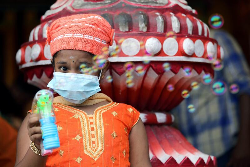 A girl wearing mask play with a bubble gun at a shrine in Batu Caves during Thaipusam, following the outbreak of a new coronavirus in China, in Kuala Lumpur, Malaysia. REUTERS