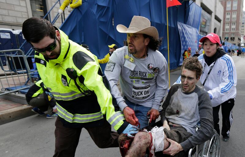 Medical responders run an injured man past the finish line the 2013 Boston Marathon following an explosion in Boston, Monday, April 15, 2013. Two explosions shattered the euphoria of the Boston Marathon finish line on Monday, sending authorities out on the course to carry off the injured while the stragglers were rerouted away from the smoking site of the blasts. (AP Photo/Charles Krupa) *** Local Caption ***  APTOPIX Boston Marathon Explosion.JPEG-0fbd1.jpg